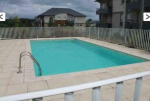 a large blue swimming pool with a fence at résidence privée YourHostHelper in Onet le Château