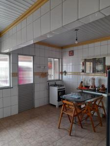 uma cozinha com mesa e cadeiras num quarto em Casa Belém em Belém