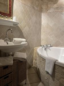 a bathroom with a sink and a bath tub at In Provence Hôtel in Venelles