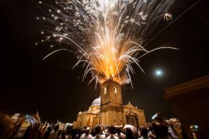 a group of people standing in front of a building with fireworks at Apartamento en el centro de Elche con terraza La Alborada in Elche