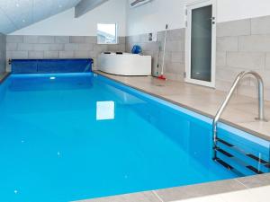 a swimming pool with blue water in a bathroom at 14 person holiday home in L gst r in Trend