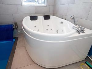 een badkamer met een wit bad en een raam bij 14 person holiday home in L gst r in Trend