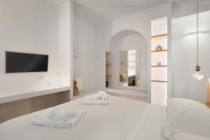 - une chambre blanche avec un lit et une télévision murale dans l'établissement Affittacamere Isabella, Terre Marine, à Levanto