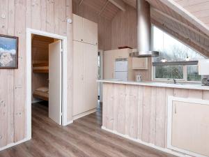a kitchen with wood paneling and a counter top at 9 person holiday home in Hemmet in Falen