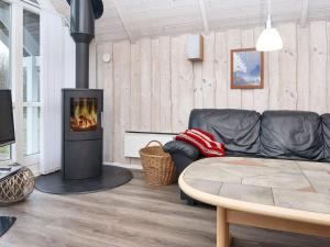 a living room with a couch and a fireplace at 9 person holiday home in Hemmet in Falen