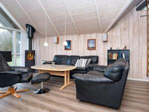 a living room with leather furniture and a table at 9 person holiday home in Hemmet in Falen