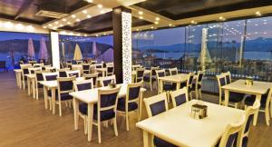 a restaurant with tables and chairs and a view of the ocean at Mara Palace Hotel in Fethiye