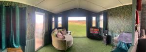a living room with a couch and a tv and a room with a window at Glamping Boutique Domes in Articlave