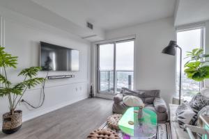 a living room with a couch and a tv at Stunning Suite in Heart of Downtown Toronto J4 in Toronto