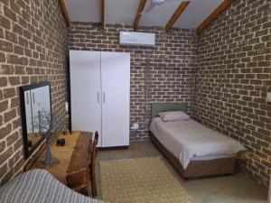 a bedroom with a bed and a brick wall at Numbi Hills Self-Catering in Hazyview