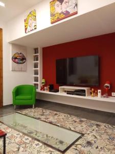 a living room with a television and a green chair at Espectacular loft dúplex in Ayora