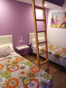 a bedroom with two beds and a ladder at Espectacular loft dúplex in Ayora