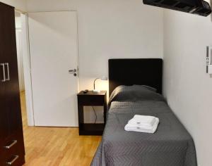 1 dormitorio con 1 cama y 1 mesa con lámpara en Amplio piso La Rural Embajada USA Shopping Outlet en Buenos Aires