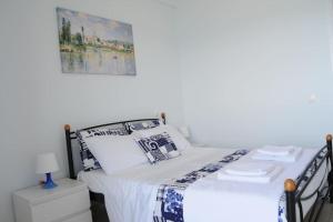 een slaapkamer met een bed en een foto aan de muur bij Sunset by the sea 1 in Loutraki