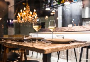 dwa kieliszki białego wina siedzące na drewnianym stole w obiekcie 19 Tile Ceramic Concept - by Unlock Hotels w mieście Caldas da Rainha