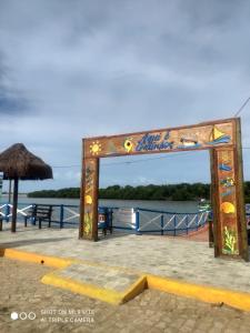 un cartello su un molo con l'acqua sullo sfondo di Pousada Galinhos a Galinhos