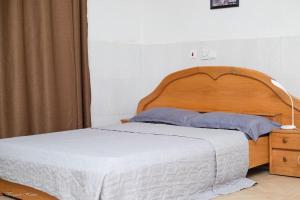 1 cama con cabecero de madera en un dormitorio en Luxury Apartments, en Kumasi