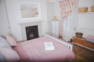a bedroom with a bed with a fireplace and a mirror at Spacious and Cosy House for 6 in Rochester