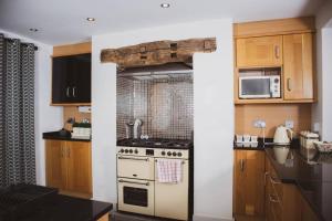 a kitchen with a stove and a microwave at Spacious and Cosy House for 6 in Rochester