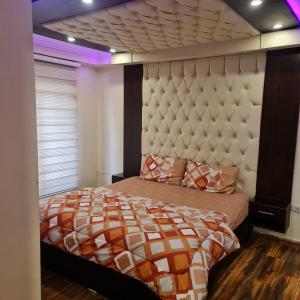Un dormitorio con una cama con un cabecero grande. en 2bd apartment 32, en Amán