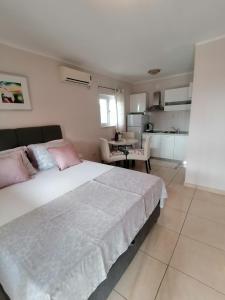 1 dormitorio con 1 cama blanca grande con almohadas rosas en Apartmani Marijana, en Lozovac