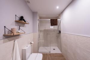 a white bathroom with a shower and a toilet at Apartamentos Jardines de la Sitarilla in Granada +128 photos