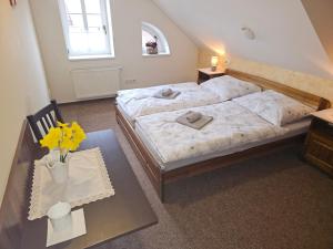 Un dormitorio con una cama y una mesa con flores. en Krkonošská chaloupka, en Černý Důl