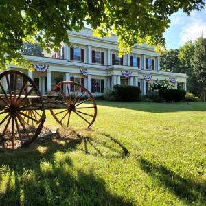 a large white house with a cannon in front of it at Arlington Inn & Spa in Arlington