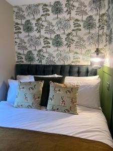 1 dormitorio con 1 cama y papel pintado con motivos florales en KILEX House Bedlinog - Rock Summit Climbing, Bike Park Wales, Zip World Tower, Brecon Beacons, Eisteddfod, Contractors, en Bedlinog