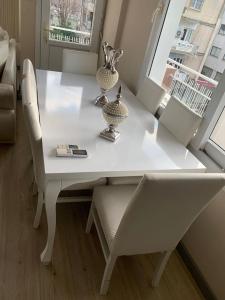 mesa de comedor blanca con sillas y ventana en LuxuryHome, en Seyhan