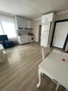 a living room with a white table and a kitchen at LuxuryHome in Seyhan