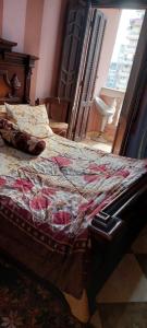 Una cama con edredón en un dormitorio en شقة مفروشة لك وحدك قريبة من مكتبة الاسكندرية, en Alejandría