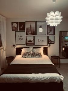 - une chambre avec un grand lit et des photos sur le mur dans l'établissement Travel Homes - Le Bright'N Cosy en pleine ville, à Mulhouse