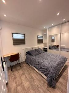 Un dormitorio con una cama y un escritorio. en Super maison f2… avec jardin, en Bondy