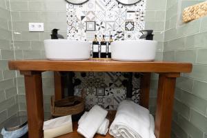 y baño con mesa, 2 lavabos y toallas. en Apartamentos La Escapada en Alhama de Aragón