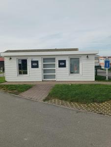 un edificio blanco con dos puertas de garaje. en Notre Nid, en Middelkerke