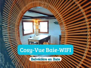 een boog in een kamer met een tafel en een stoel bij Le Belvédère en baie, vue sur la baie in Saint-Valery-sur-Somme