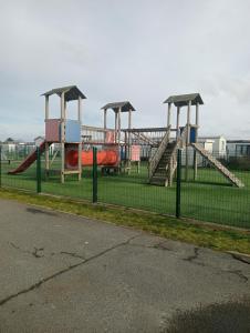 un parque con parque infantil con toboganes y columpios en Notre Nid, en Middelkerke