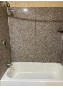 a white bath tub sitting in a bathroom at Regency Inn in Perry