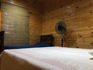 a bedroom with a bed and a fan at Las Azucenas in Ranchos