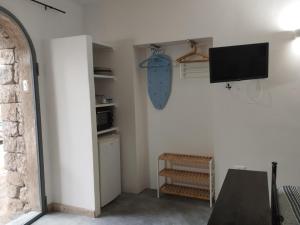 a living room with a tv and a table at Le casette di Marilena Agave Iucca in Pantelleria