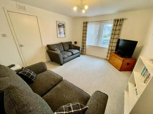 a living room with a couch and a television at Spacious 2 Bedroom Home in Picturesque Cullen in Cullen