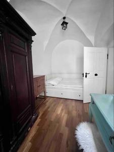 Cette chambre blanche dispose d'un lit et d'une porte. dans l'établissement Medieval Castle in Kamnik City Center - Trutzturn, à Kamnik