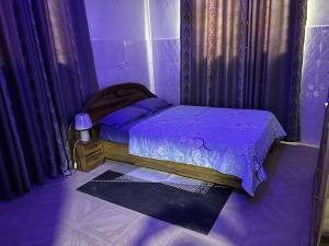 a purple bedroom with a bed with purple sheets at Luxury Spacious Apartment in Kumasi