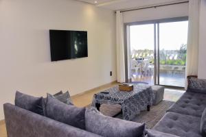 sala de estar con sofá, mesa y TV en Luxurious Apt with Pool&Sea View en Pont Blondin