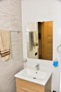 y baño con lavabo y espejo. en Luxurious Apt with Pool&Sea View en Pont Blondin