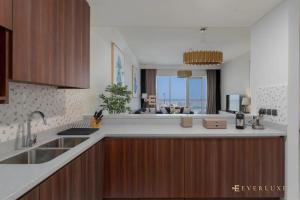 a kitchen with a sink and a counter top at Everluxe Palm Views 3 Bedroom in Dubai