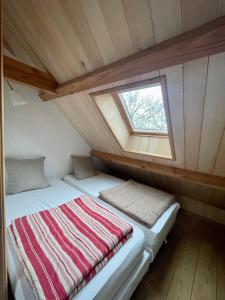 La Grangette de Paunac في Cazillac: سرير في غرفة صغيرة مع نافذة