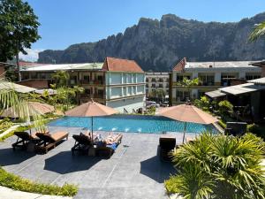 a group of people sitting in chairs next to a swimming pool at Eco Inn Cottage Krabi at Aonang in Ao Nang Beach