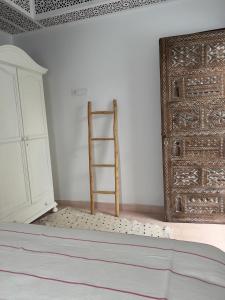 a room with a ladder next to a door at Dar Narjis in Asilah